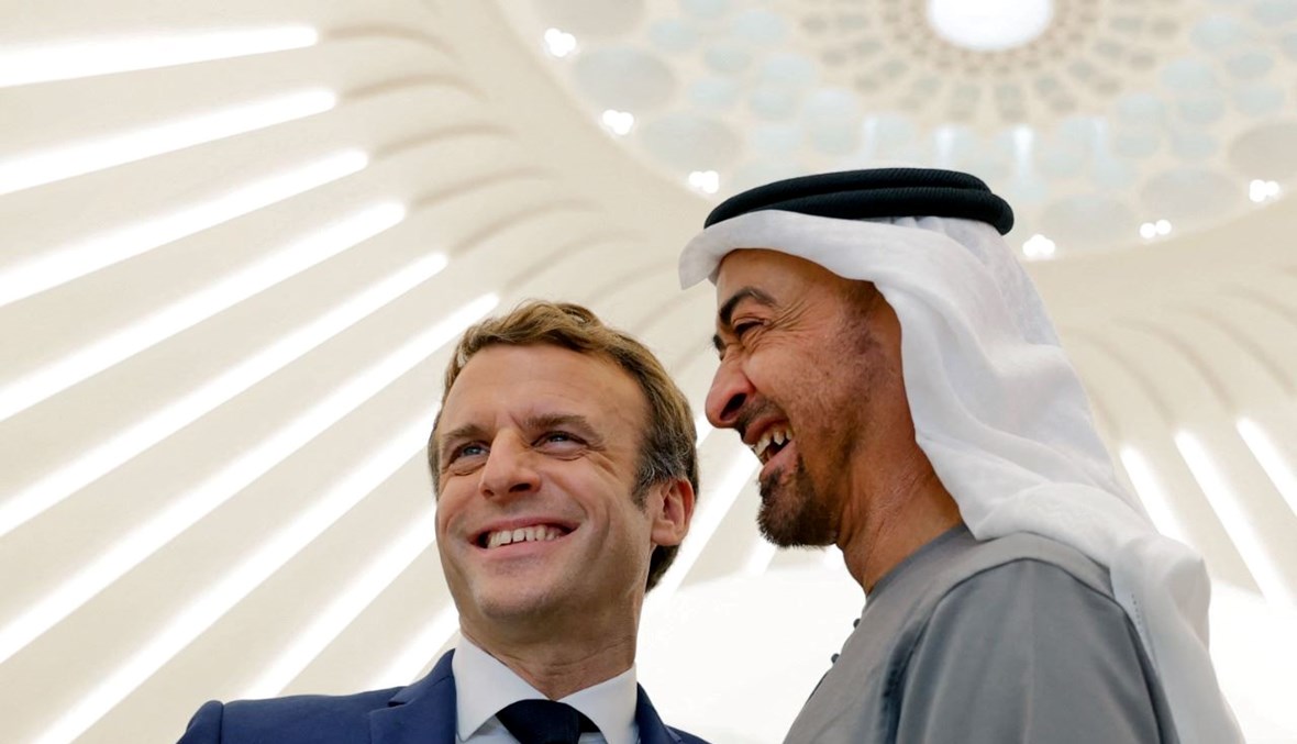 ماكرون  وولي عهد أبوظبي محمد بن زايد يبتسمان خلال جولة في الجناح الفرنسي في معرض إكسبو دبي في دبي (3 ك1 2021، أ ف ب).