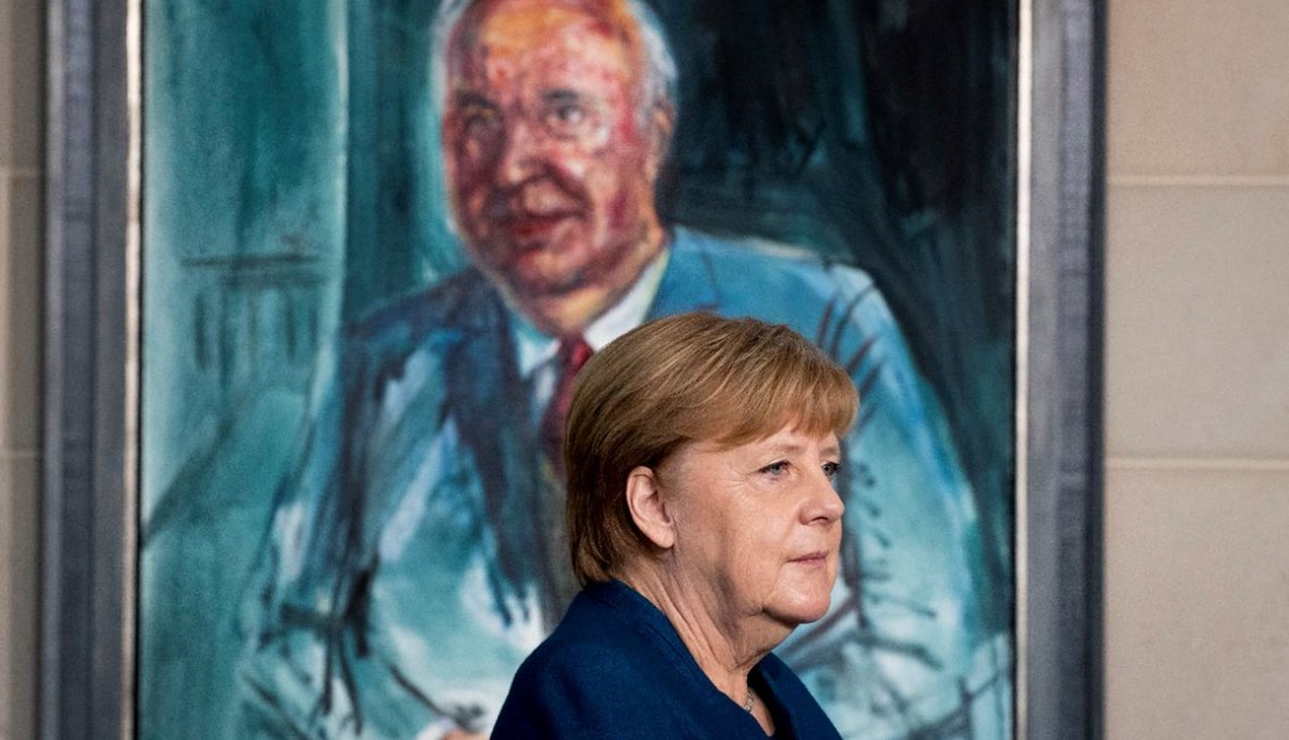 ميركل تقف أمام لوحة للمستشار السابق هيلموت كول للفنان الألماني ألبريشت جيسه خلال مناسبة في المستشارية في برلين (7 ك2 2020، أ ف ب).