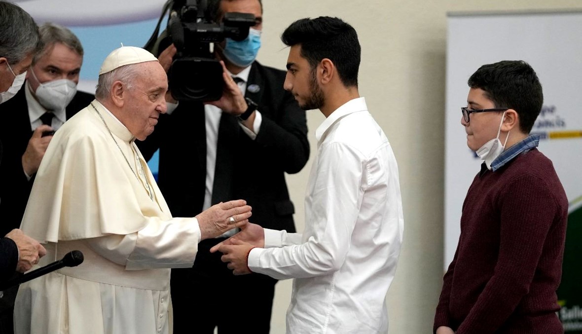 البابا فرنسيس ملتقيا عبود غابو وشقيقه ماريو، وهما من اللاجئين من سوريا، خلال لقاء مع شباب في مدرسة القديس ديونيسيوس للأخوات الأورسولين في ماروسي بأثينا (6 ك1 2021، أ ف ب). 