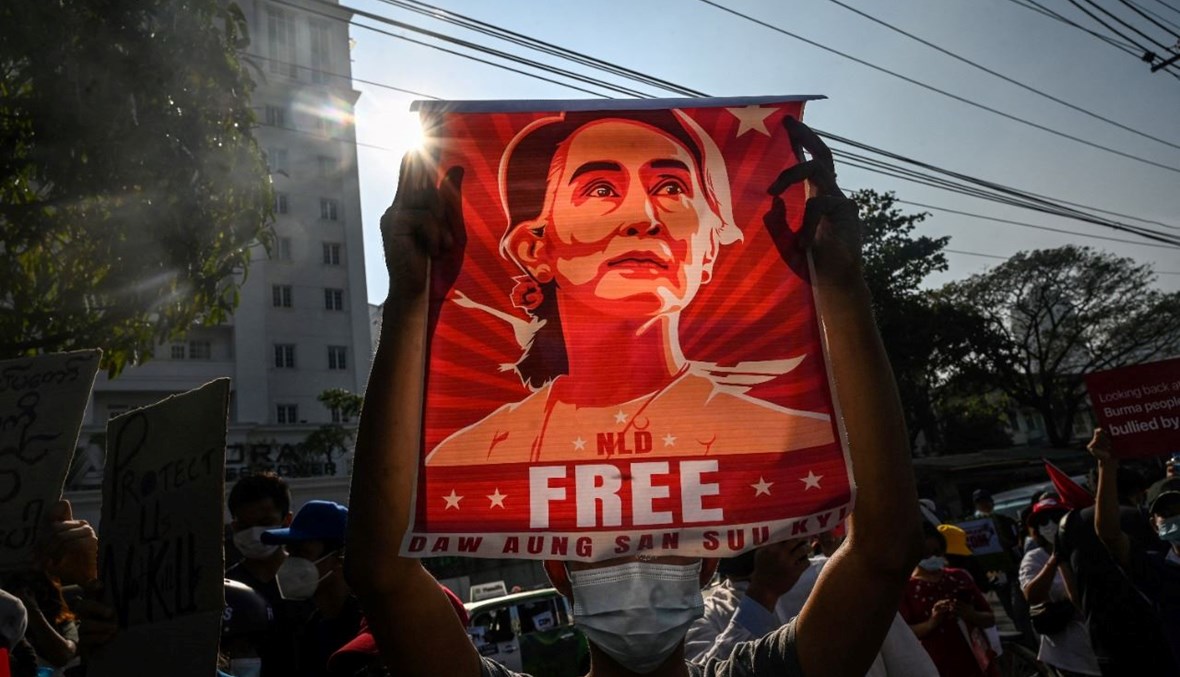 متظاهر يحمل صورة أونغ سان سو تشي أمام بنك ميانمار المركزي في يانغون خلال احتجاج على الانقلاب العسكري (15 شباط 2021، أ ف ب).