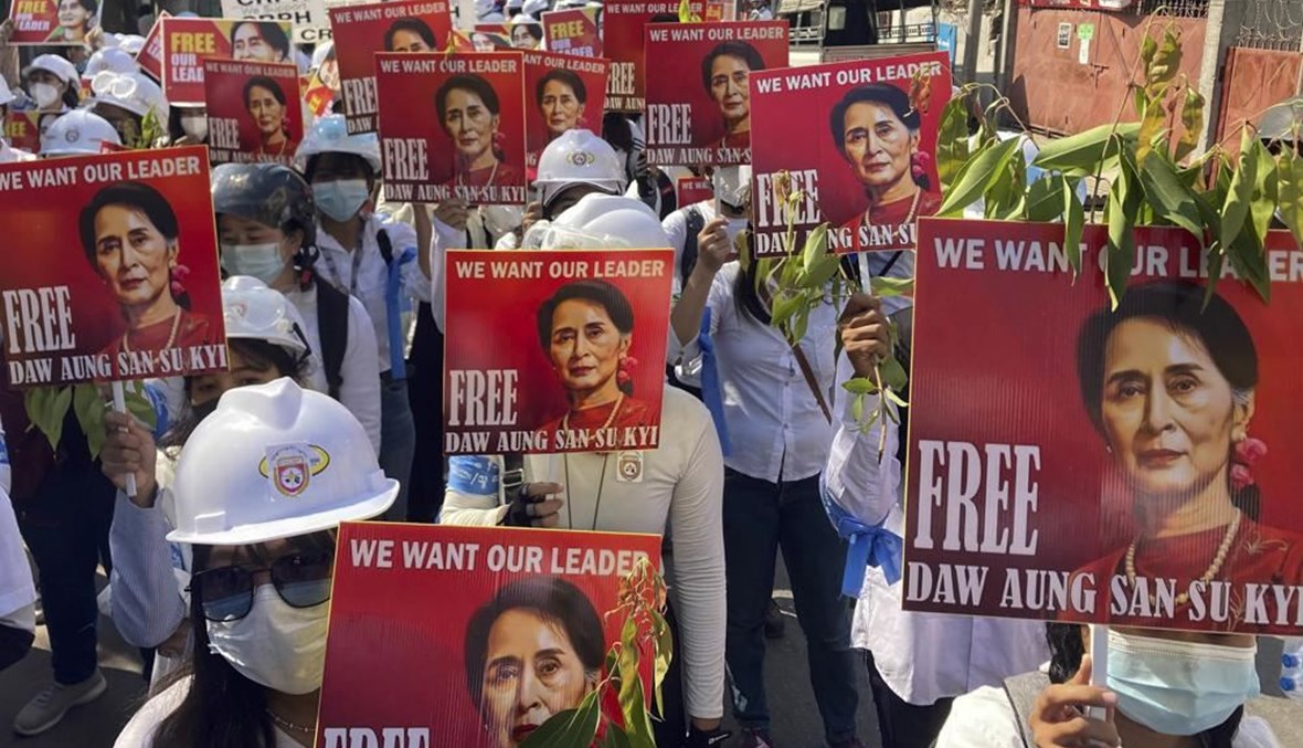 متظاهرون يحملون صورًا لأونغ سان سو تشي خلال احتجاج ضد للانقلاب في ماندالاي  بميانمار (5 آذار 2021، أ ب). 