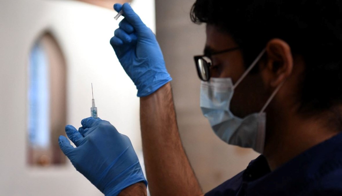 عامل طبي يجهز جرعات من لقاح كورونا في مركز تطعيم موقت أقيم داخل كنيسة سانت جون في غرب لندن (4 ك1 2021، أ ف ب). 