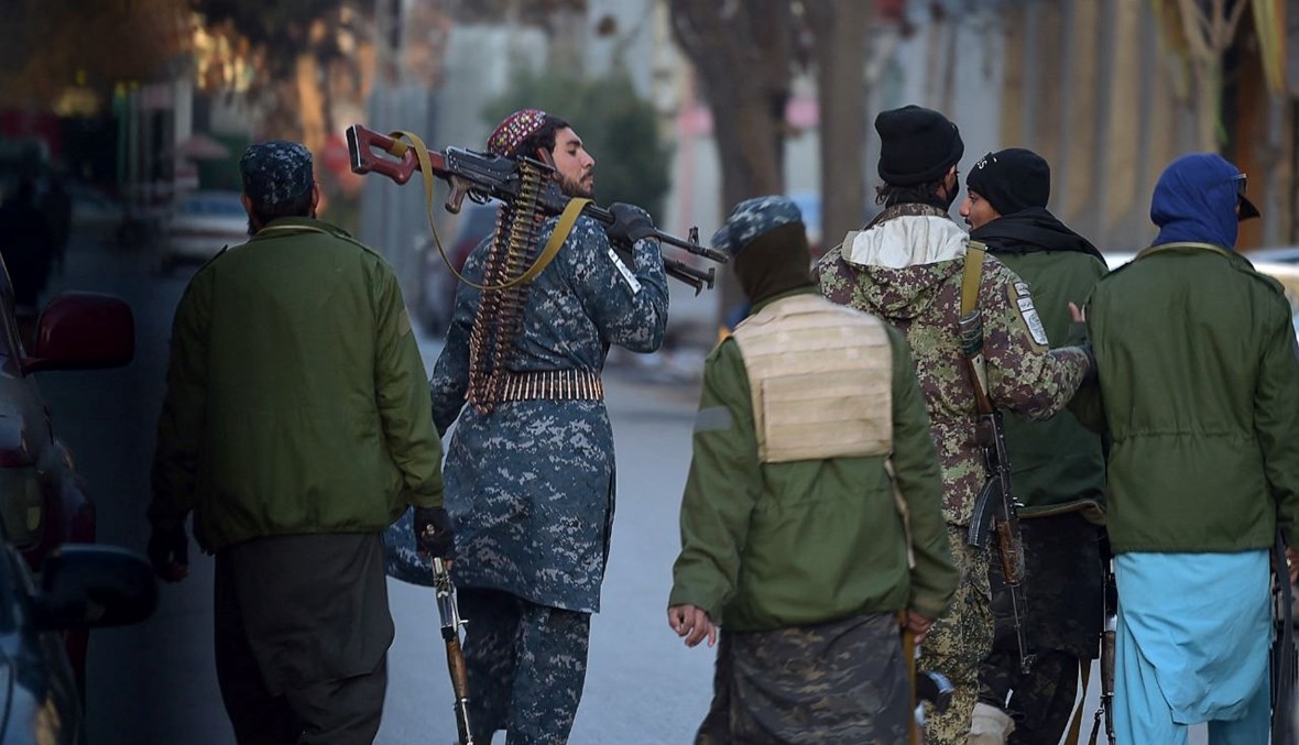 مقاتلون من طالبان يمشون على طريق في حي شهر ناو في كابول (9 ك1 2021، ا ف ب). 