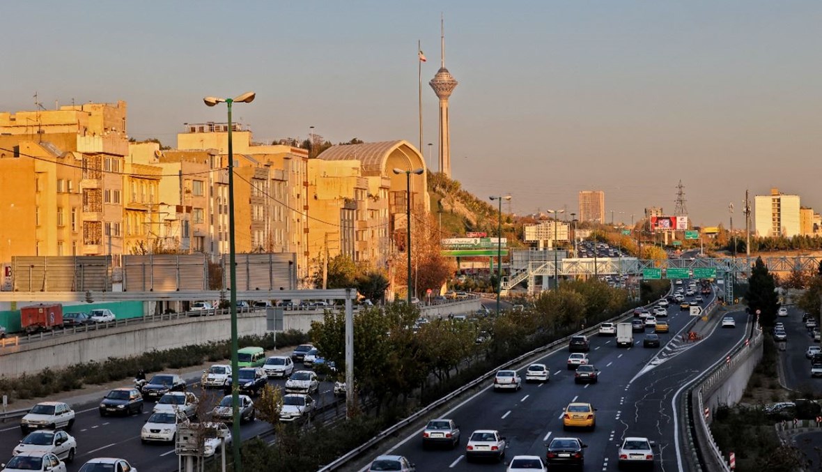 سيارات على طريق سريع في طهران. وبدا برج ميلاد للاتصالات (8 ك1 2021، أ ف ب). 