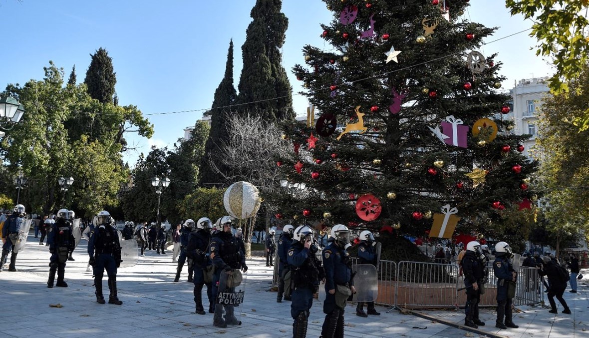 عناصر من شرطة مكافحة الشغب انتشروا قرب متظاهرين يشاركون في مسيرة ضد القمع البوليسي في وسط أثينا (6 ك1 2021، أ ف ب). 