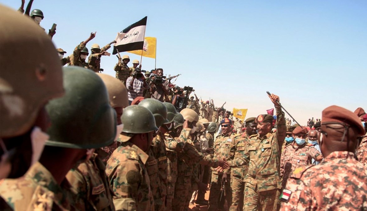 البرهان يحيي الجنود في ختام مناورة عسكرية في منطقة المعقل بولاية شمال نهر النيل (8 ك1 2021، أ ف ب). 
