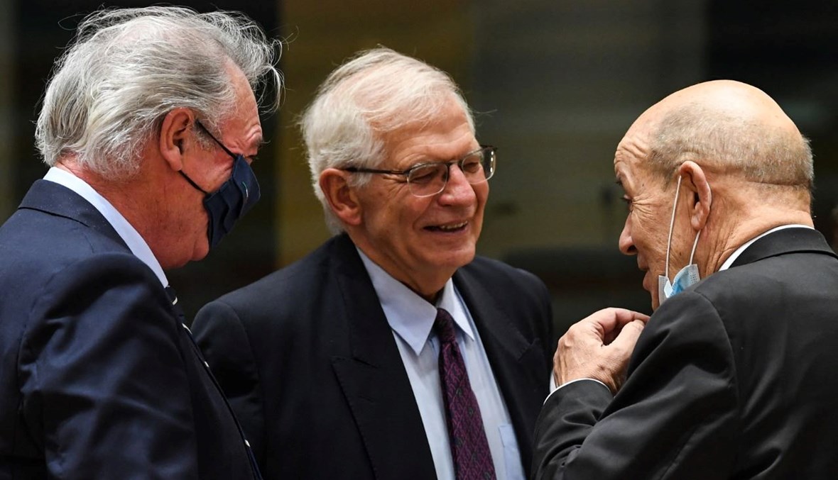 لودريان (إلى اليسار) يتحدث الى بوريل (في الوسط) خلال اجتماع لمجلس الشؤون الخارجية في مقر الاتحاد الأوروبي في بروكسيل (13 ك1 2021، أ ف ب). 