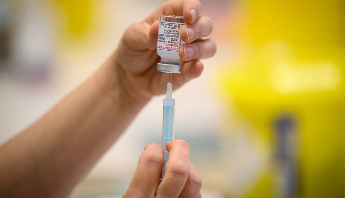عامل طبي يجهز حقنة بلقاح كورونا في مركز تطعيم قرب رامسغيت في بريطانيا (16 ك1 2021، أ ف ب). 