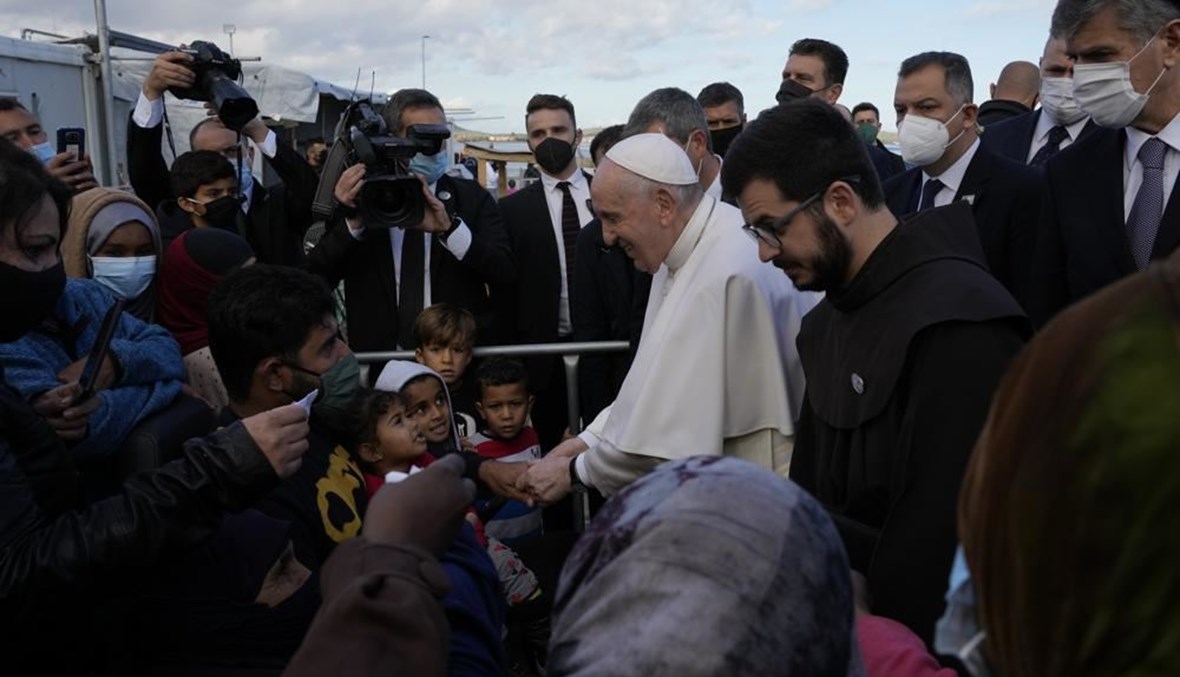البابا فرنسيس ملتقيا مهاجرين خلال زيارته مخيم كاراتيبي في جزيرة ليسبوس باليونان (5 ك1 2021، أ ب). 