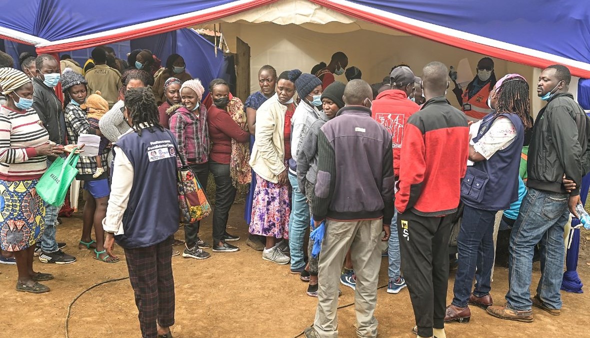 اشخاص ينتظرون تلقي لقاح كورونا في مستوطنة نجاندو في نيروبي (16 ك1 2021، أ ف ب). 