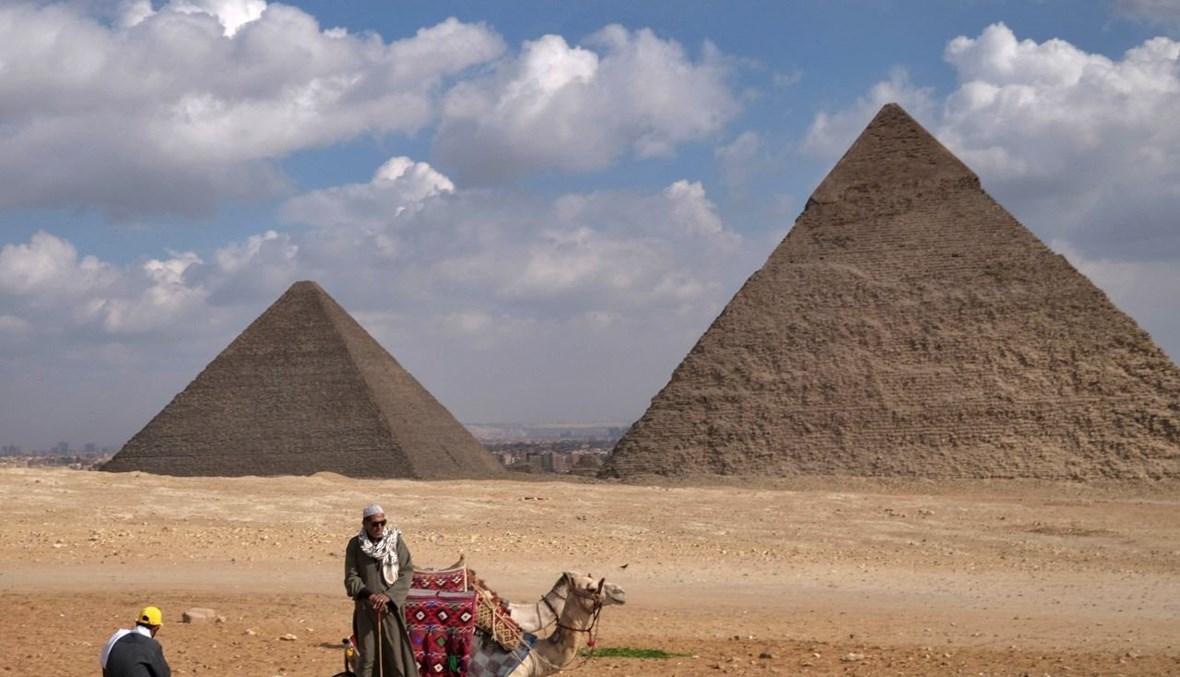 رجال بالقرب من اهرامات الجيزة في الضواحي الجنوبية الغربية  للقاهرة (17 ك1 2021، أ ف ب).