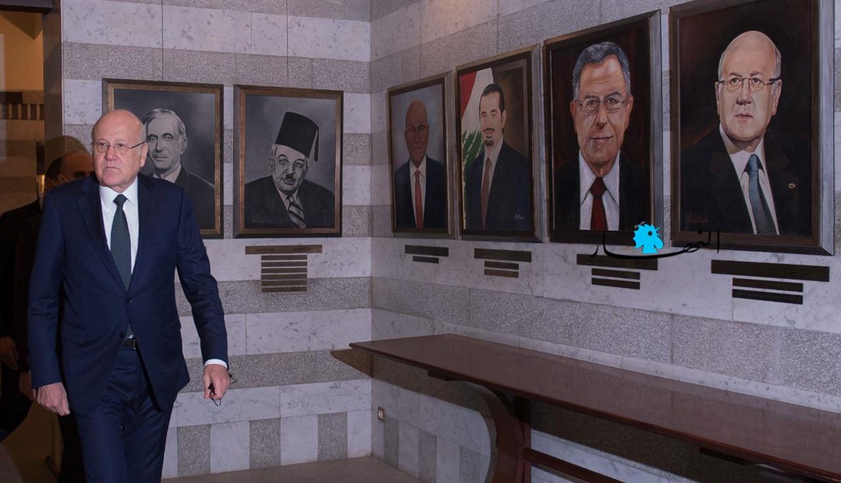 رئيس مجلس الوزراء نجيب ميقاتي في السرايا الحكومية إلى جانب صور الرؤساء السابقين للحكومات (نبيل اسماعيل).
