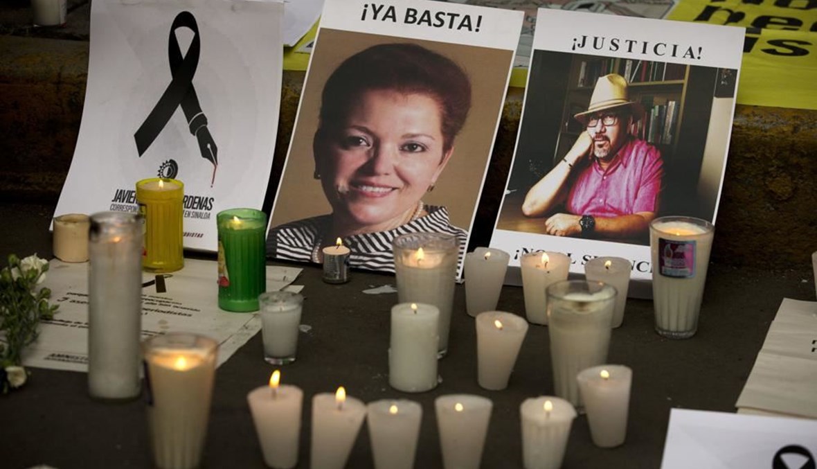 شموع اضيئت أمام صور الصحافيين المقتولين ميروسلافا بريتش (الى اليسار) وخافيير فالديز، خلال تظاهرة ضد مقتل الصحافيين أمام مقر وزارة الداخلية في مكسيكو سيتي (16 ايار 2017، أ ب). 