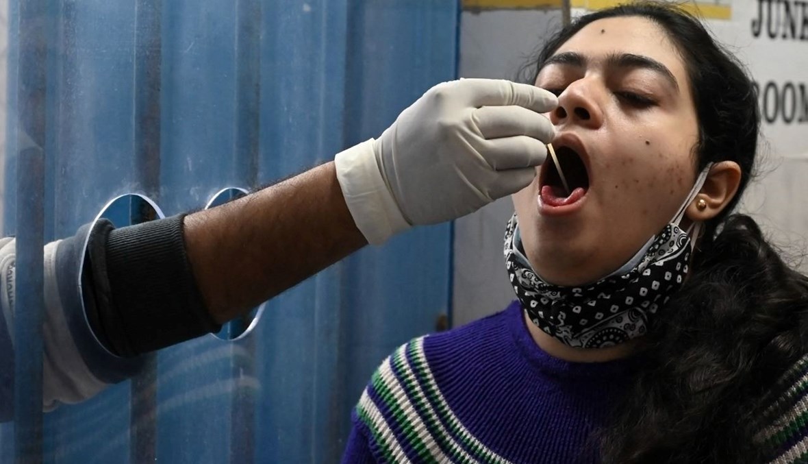 امرأة تخضع لاختبار كشف كورونا في عيادة بلدية في كولكاتا بالهند (3 ك2 2022، أ ف ب). 