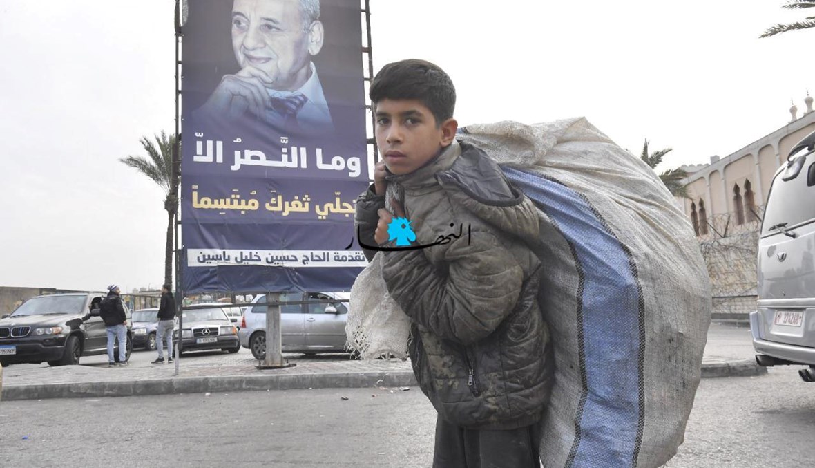 فتى يحمل كيساً من النفايات في شوارع بيروت أثناء قطع الطرق في "خميس الغضب" (نبيل اسماعيل).