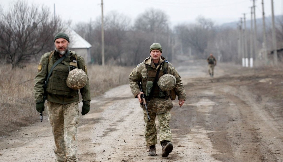 جنديان أوكرانيان يقومان بدورية في مستوطنة ترويتسكي في منطقة لوغانسك قرب خط المواجهة مع الانفصاليين (22 شباط 2022، أ ف ب). 